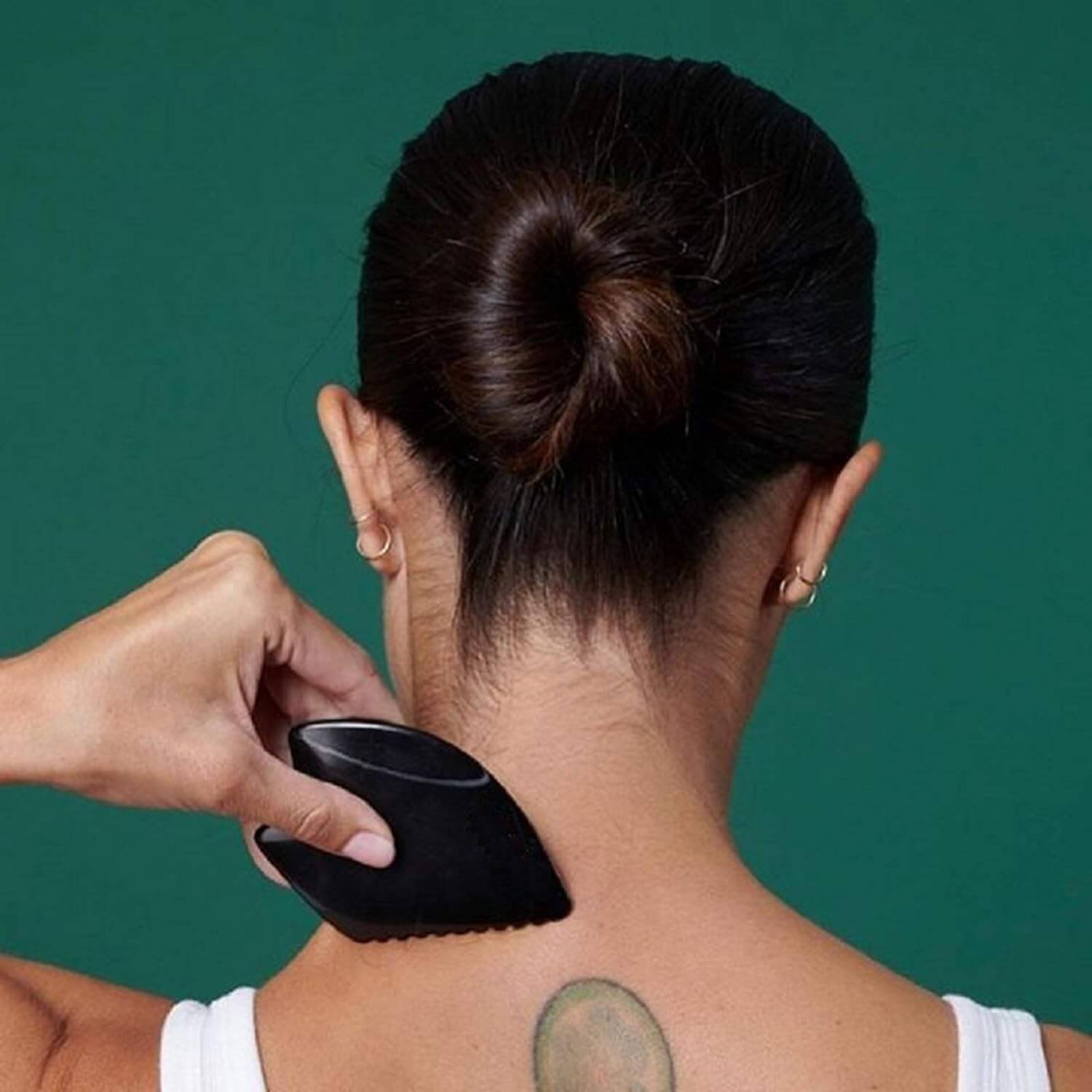 Model using the Bian Stone Gua Sha on the back of her neck