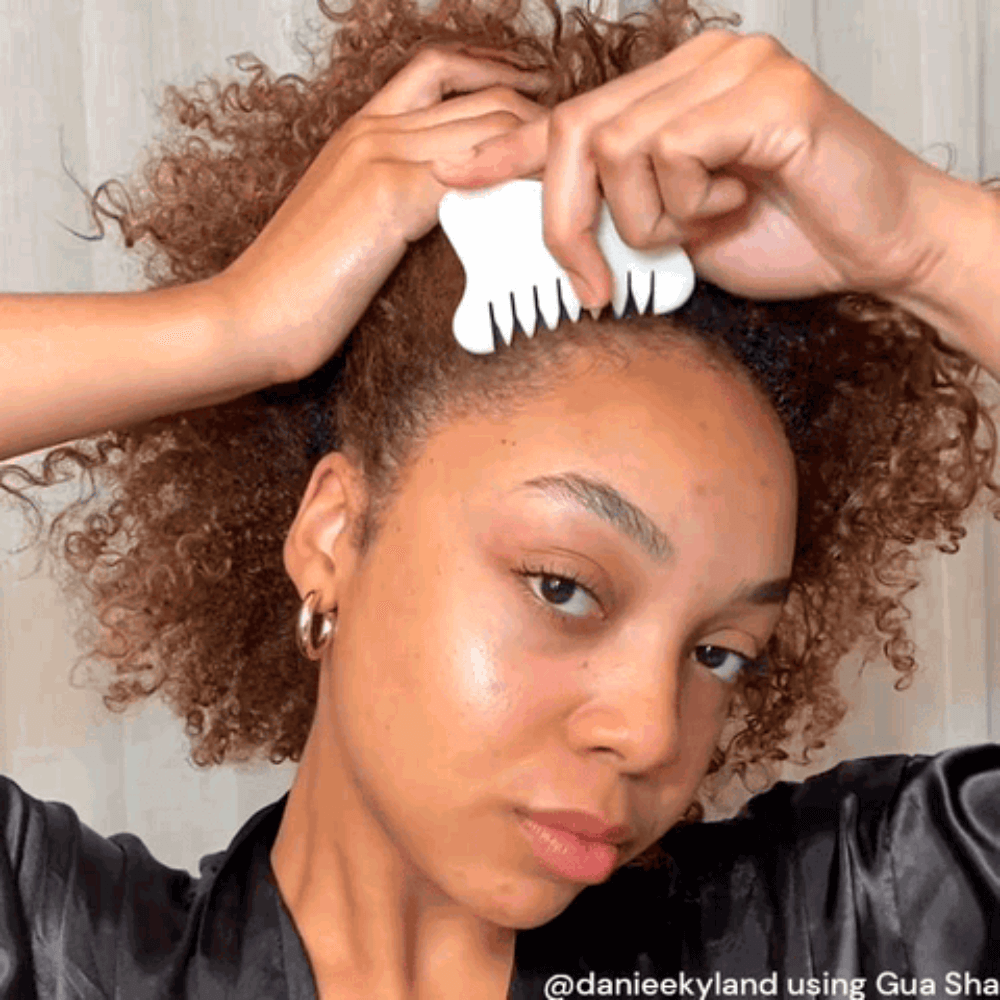 Model using the Gua Sha Comb on her scalp